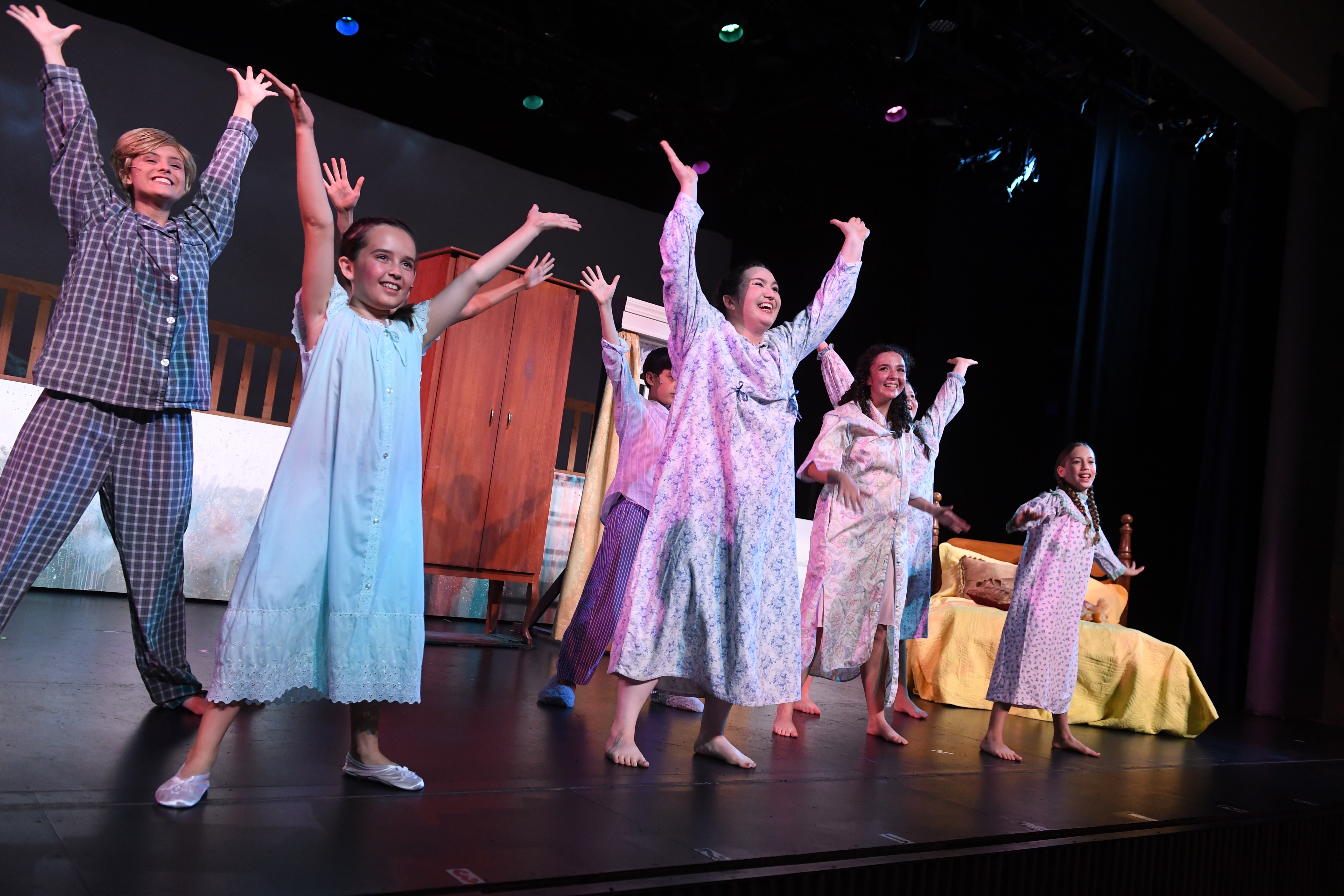 children smiling with hands up